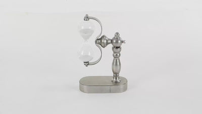 Traditional style hourglass made from the metal stand, mount in gray color with semi-glossy finish and glass body filled with snow white sand. Hourglass is spinning in 360 degrees. Background is all white