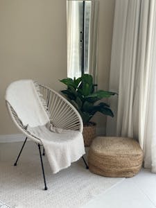 A white chair with a potted plant in front of it