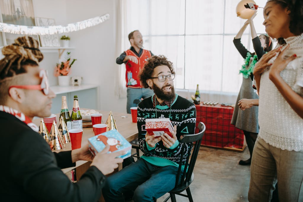 Group of coworkers enjoying an office Christmas party with gifts and decorations.