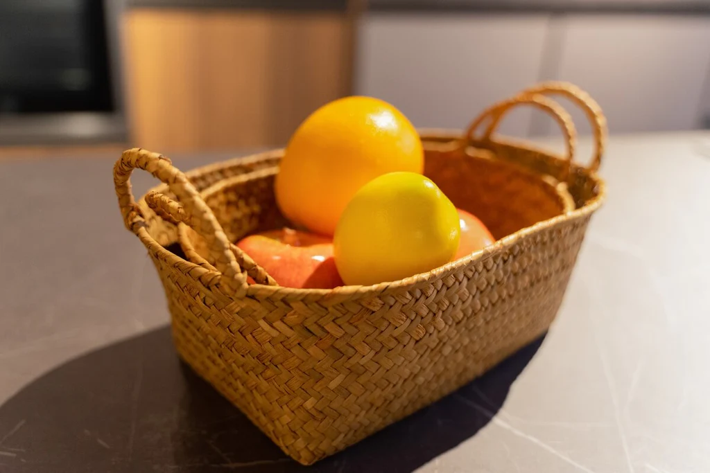 Oranges in a woven basket on the kitchen island
