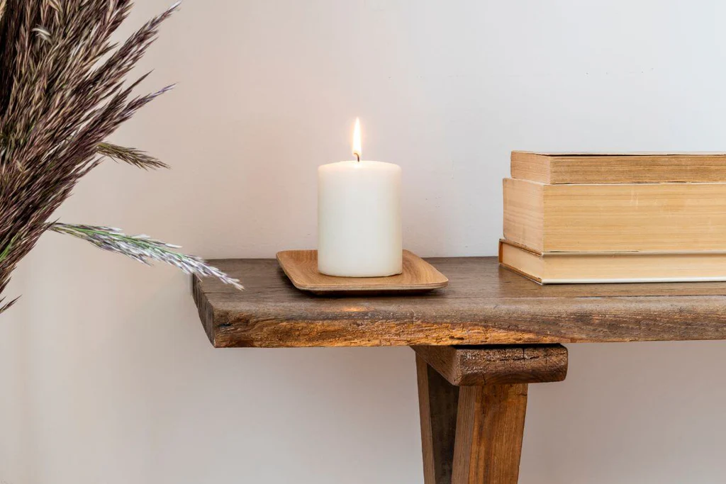 Wooden side table with a white candle on it