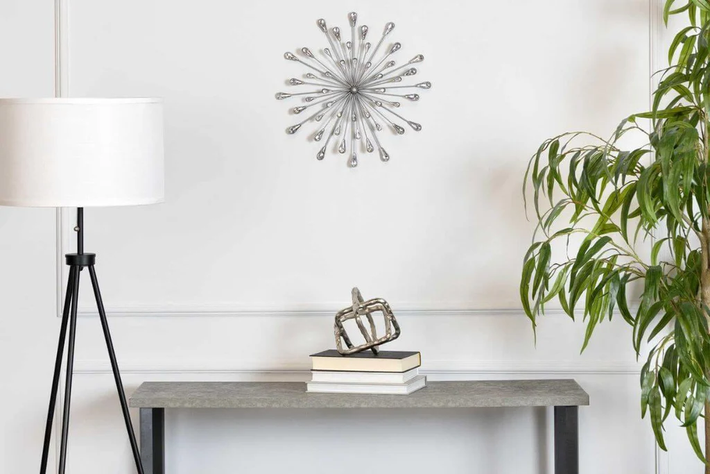 Silver burst wall art above side table