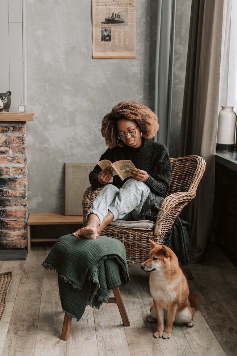 A Woman Sitting on the Armchair while Reading