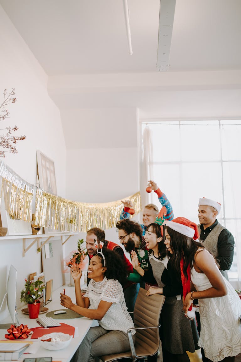 Colleagues enjoying a festive Christmas party in the office, celebrating with holiday decor and joyful expressions.